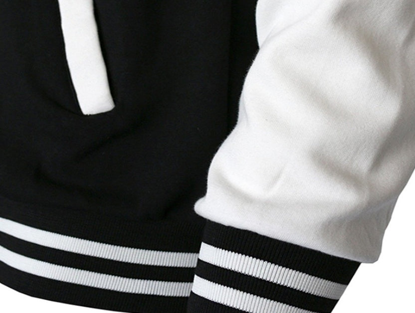 Close-up of a men's baseball jacket showcasing its black and white design and striped cuffs.
