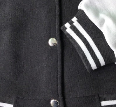 Close-up of a men's baseball jacket showcasing buttons and striped cuffs for stylish casual wear.